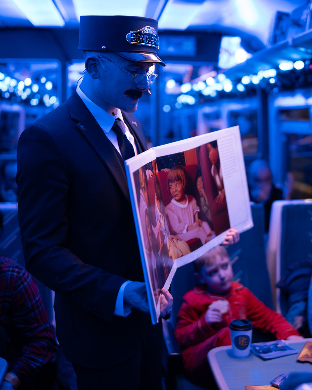 conductor with book on board the polar express train ride